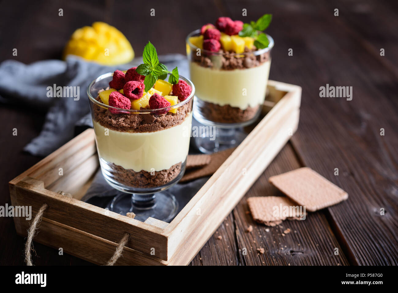Layered mango dessert with cream cheese, crushed biscuits and freeze