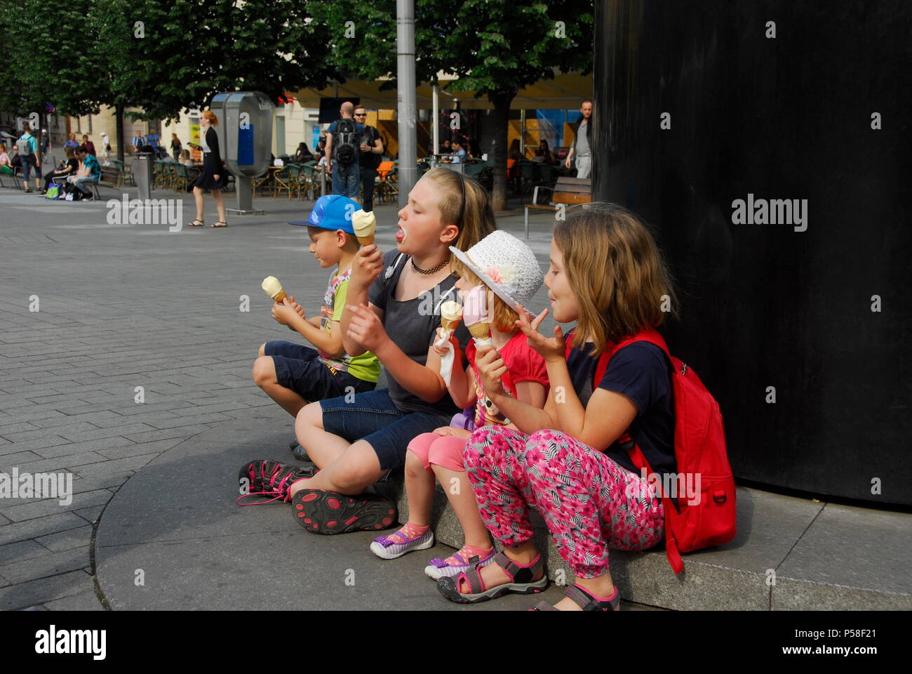 Children eating ice cream at base of Brno astronomical clock on Old Brno, South Moravia, Czech Republic Stock Photo