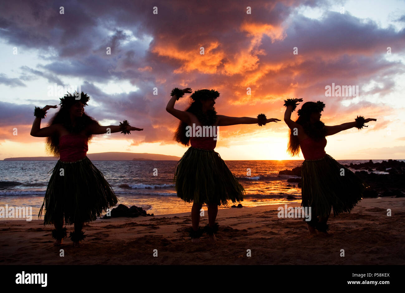 Three hula dancers at sunset at Palauea Beach, Maui, Hawaii. Stock Photo