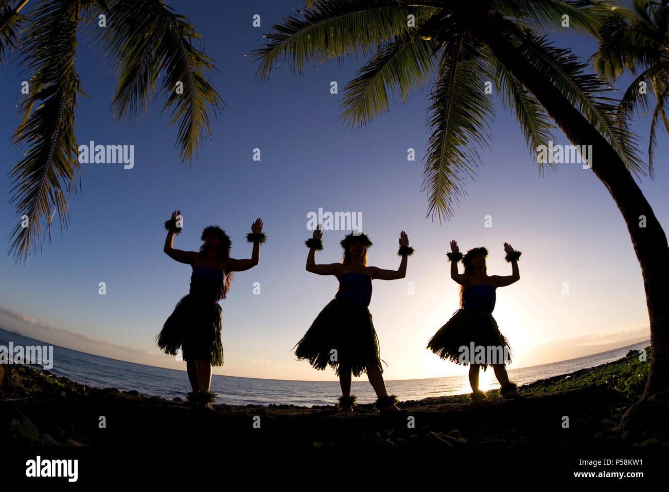 Three hula dancers at sunset at Olowalu, Maui, Hawaii. Stock Photo