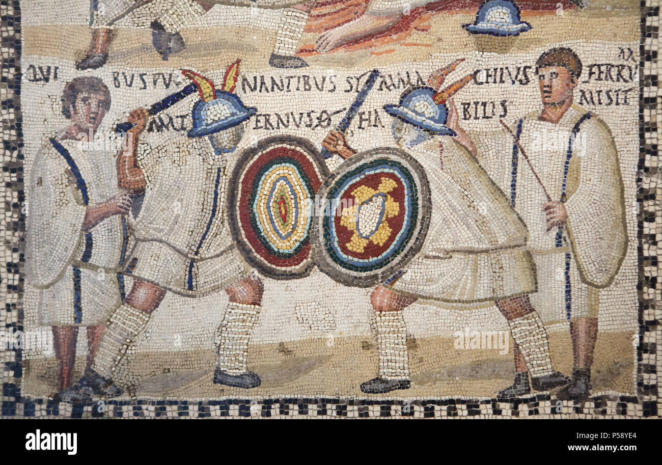 Gladiator fight depicted in the Roman mosaic from the 3rd century AD on display in the National Archaeological Museum (Museo Arqueológico Nacional) in Madrid, Spain. According to the Latin inscription, the murmillo (Roman armed gladiator) Symmachus is fighting versus the murmillo Maternus, cheered on by the lanistae (gladiator trainers). Stock Photo