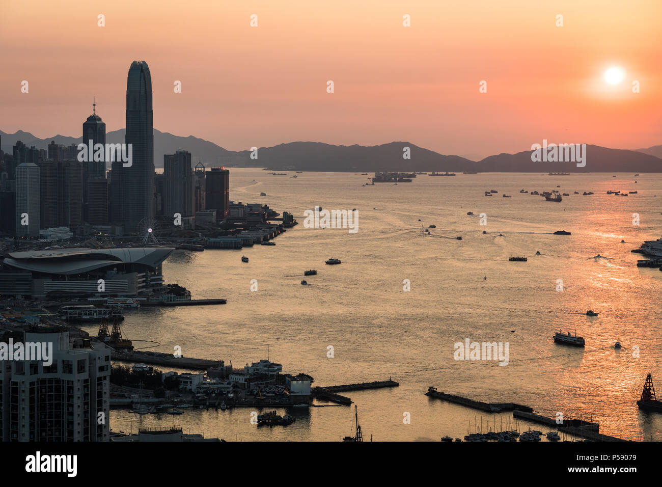 Stunning view of the sunset above the Victoria harbor in Hong Kong with the skyscraper of Hong Kong island in the left in China Stock Photo