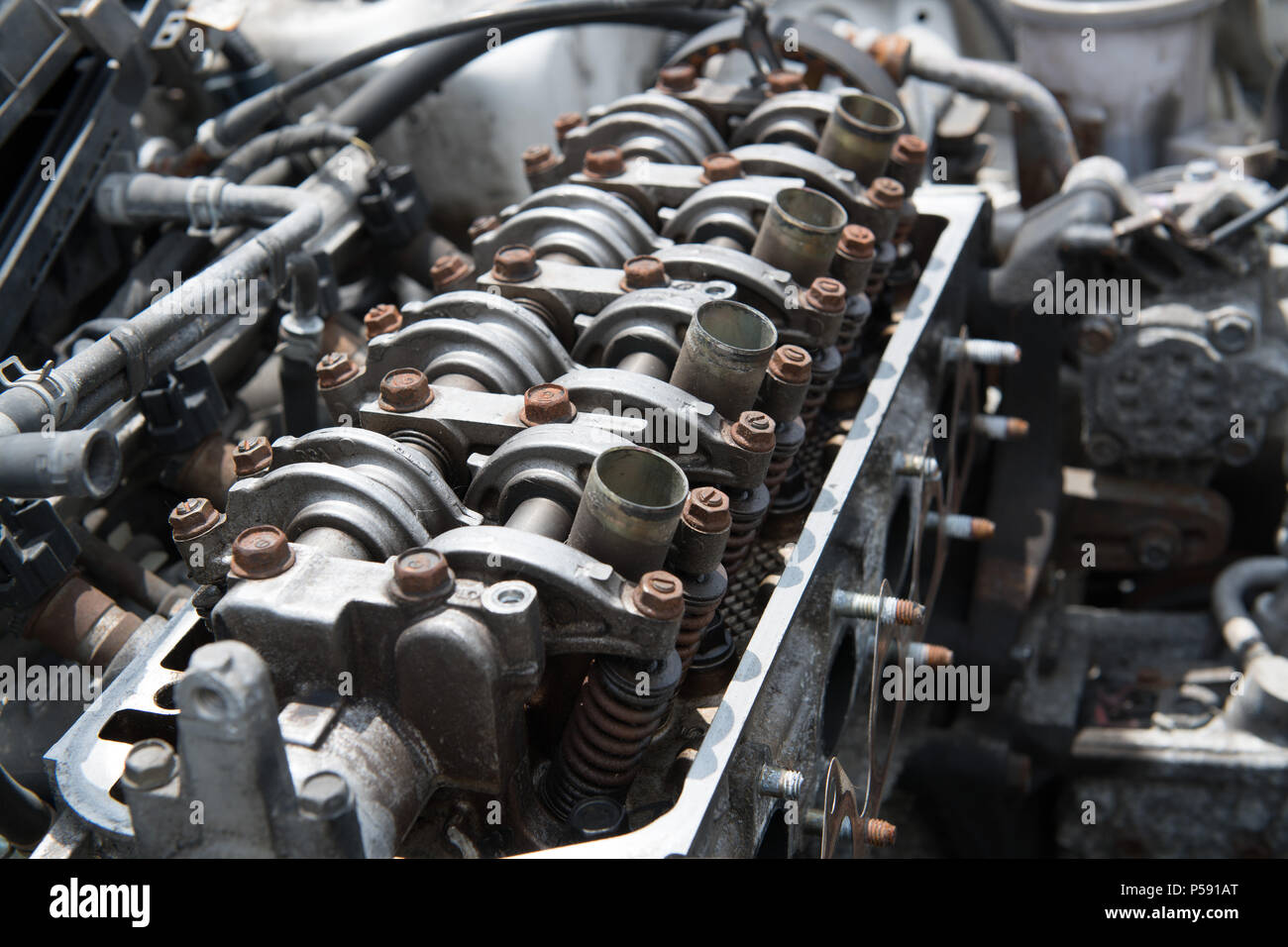 An open engine block with rusted bolts reveals the four cylinders of