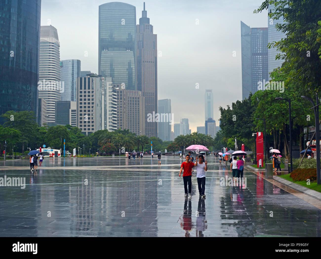Guangzhou, China - June 06, 2018; A Wet Day doesn't deter walkers in Guangzhou New Town, China Stock Photo