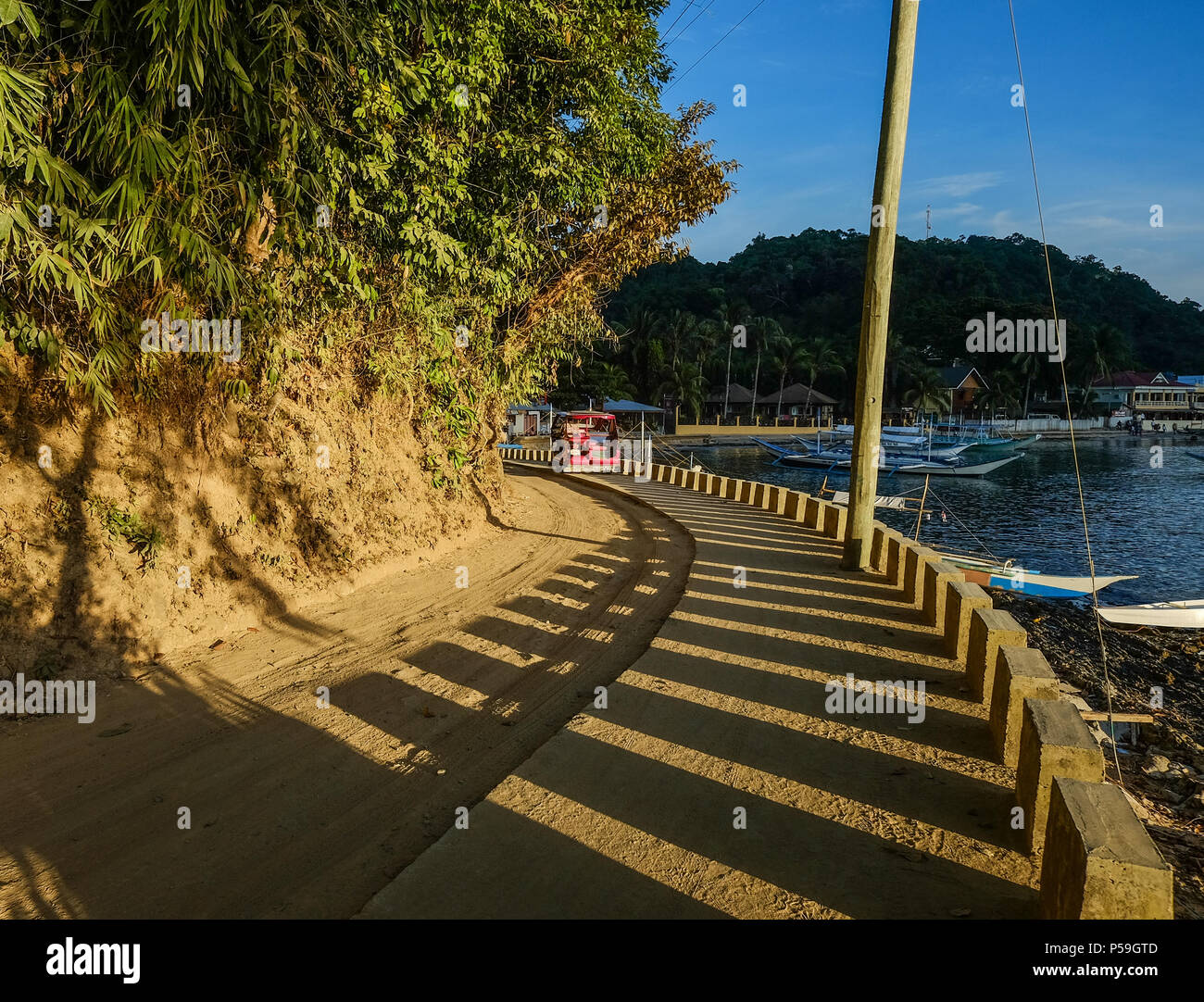 Seaside road at sunset in Palawan, Philippines. Palawan is the island of idyllic tropical beauty. Stock Photo