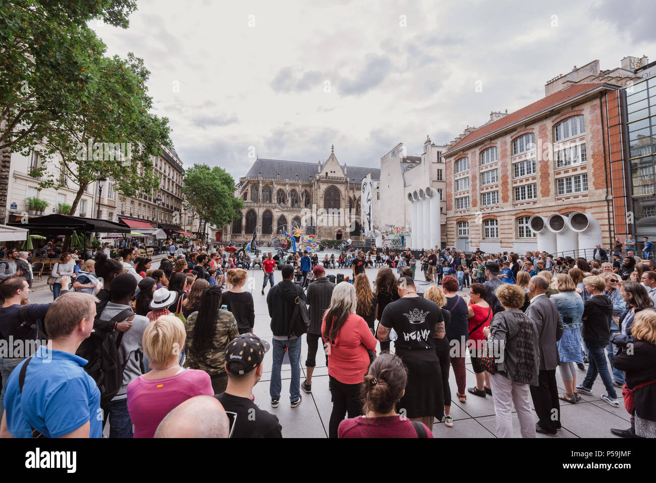 Paris, France - August 11, 2017. People watch street performance in front of whimsical public Stravinsky fountain near centre Georges Pompidou. Urban  Stock Photo
