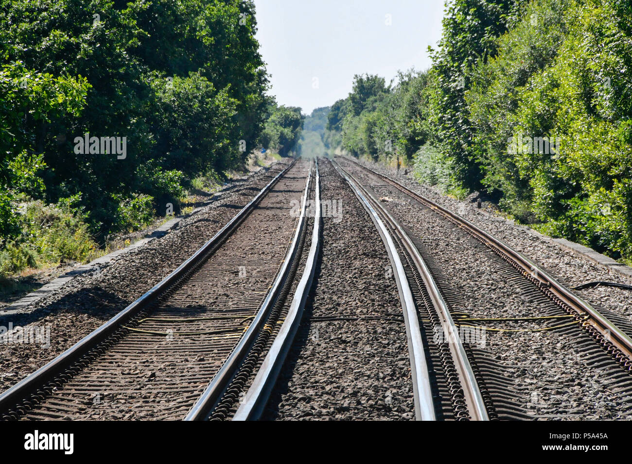 Wareham, Dorset, UK.  26th June 2018. UK Weather.   View from a level crossing near Wareham in Dorset as delays on South Western Railways in Dorset after a small fire under a train between Surbiton and Weybridge blocked the West bound line.  This incident is on top of the speed restrictions on the railways due to the risk of the lines buckling due to the hot temperatures from the current heatwave.  Picture Credit: Graham Hunt/Alamy Live News Stock Photo