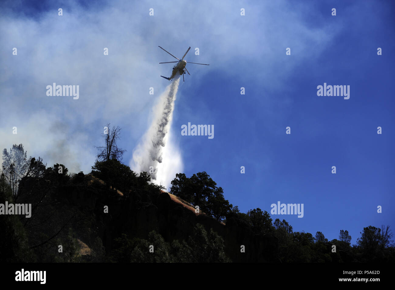 June 24, 2018 - Clearlake Oaks, California, USA - The Pawnee Fire in Lake County continued to show aggressive fire behavior in the early afternoon of Sunday. Fire crews focused on structure protection while helicopters make water drops to assist the strike teams on the ground. (Credit Image: © Neal Waters via ZUMA Wire) Stock Photo