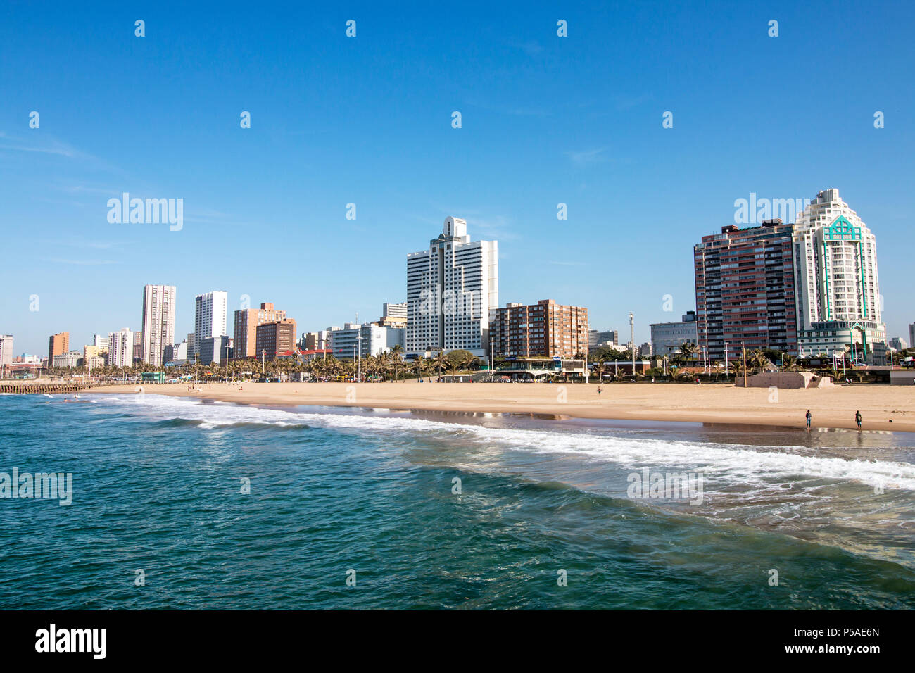 Ocean and beach against Golden Mile coastal city skyline and blue sky