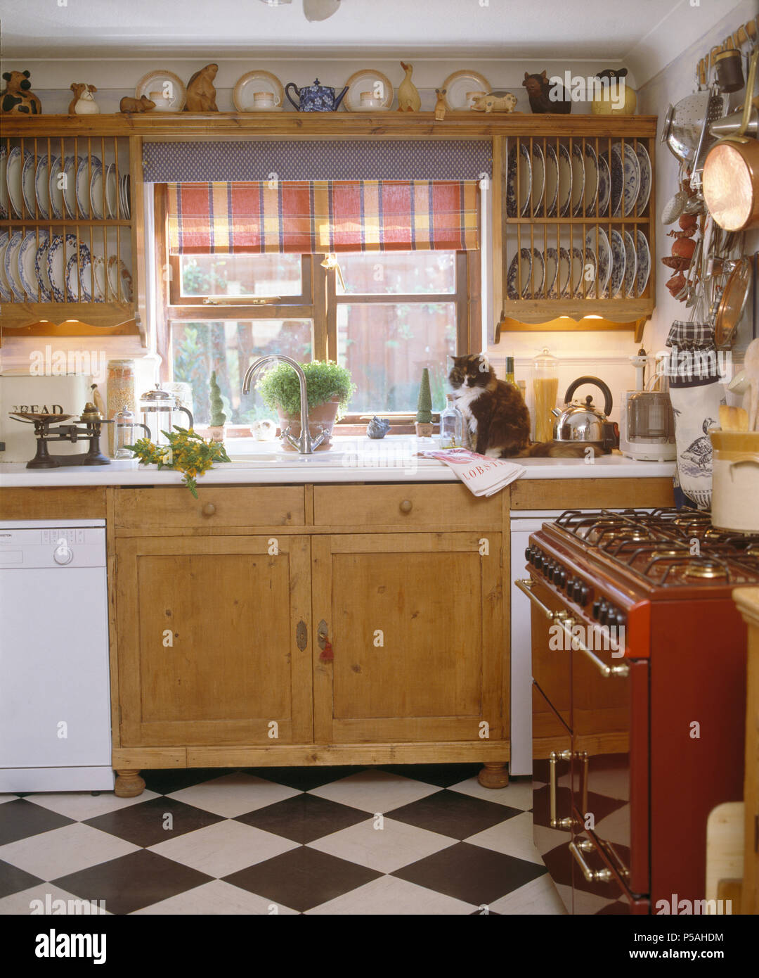 https://c8.alamy.com/comp/P5AHDM/wooden-plate-racks-either-side-of-window-with-red-blind-above-sink-in-cottage-kitchen-with-blackwhite-chequer-board-floor-P5AHDM.jpg