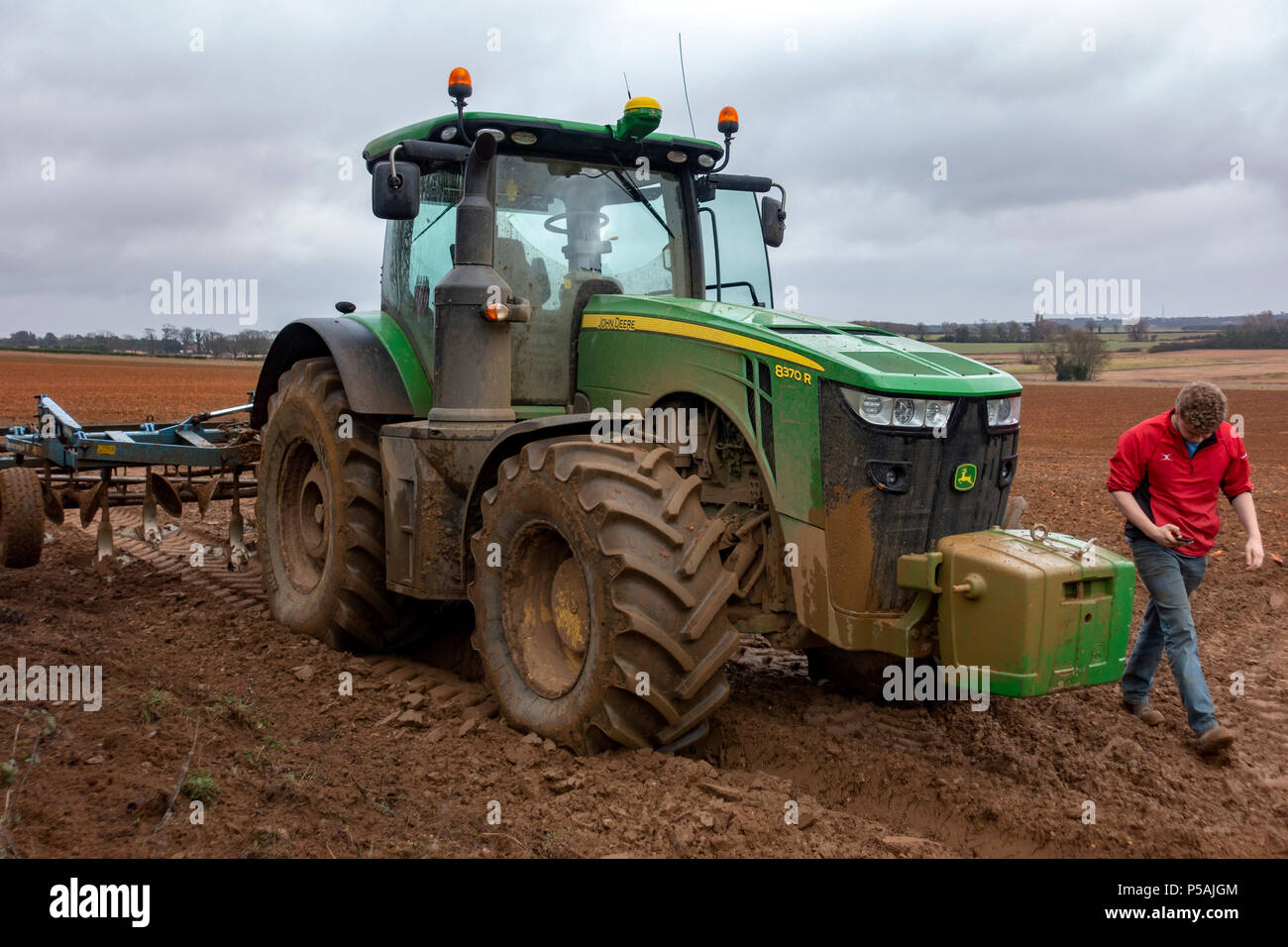 Tractor driver looking at the weather forecast on a smart phone Stock Photo