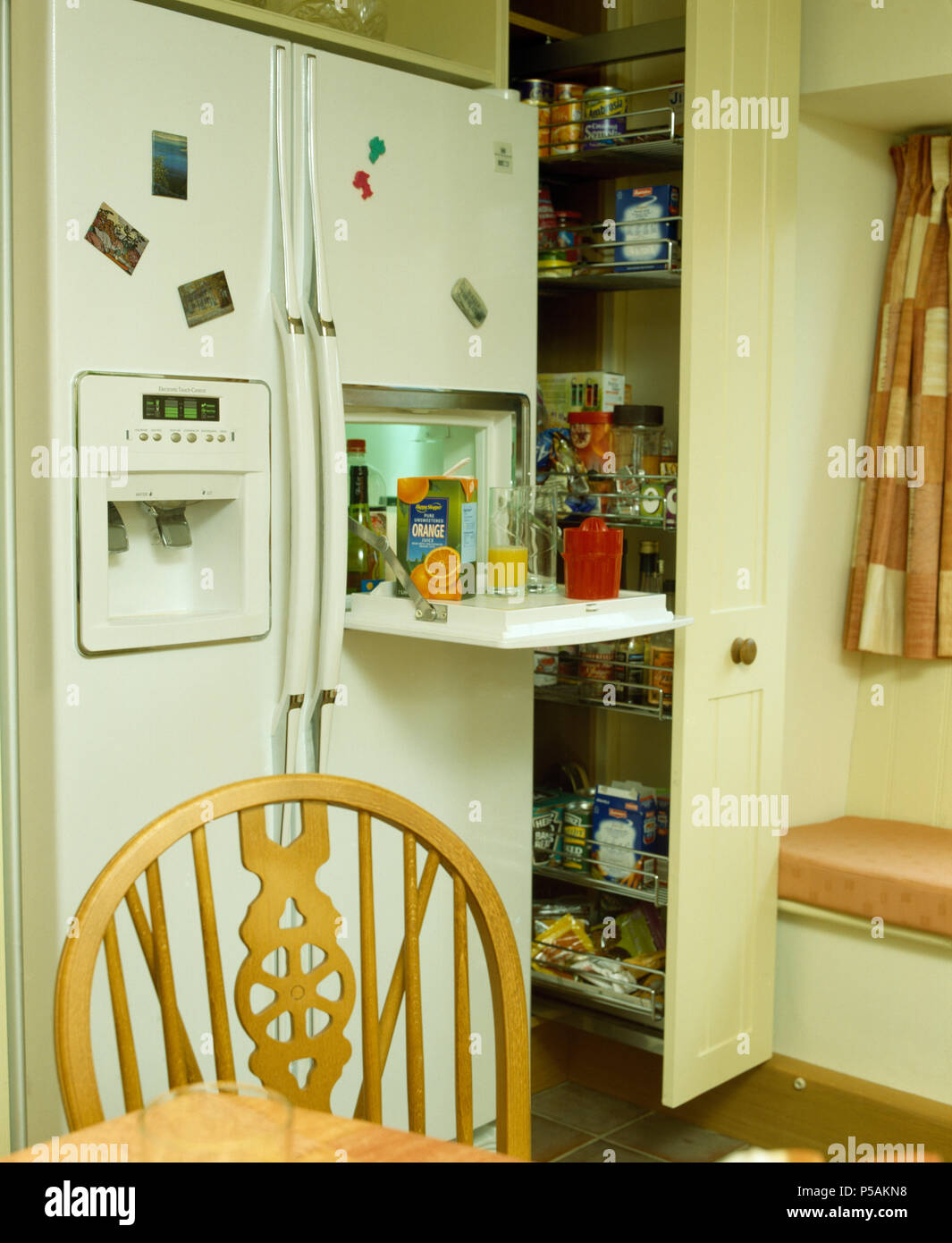 Kitchen with American style refrigerator and pull-out larder cupboard Stock Photo