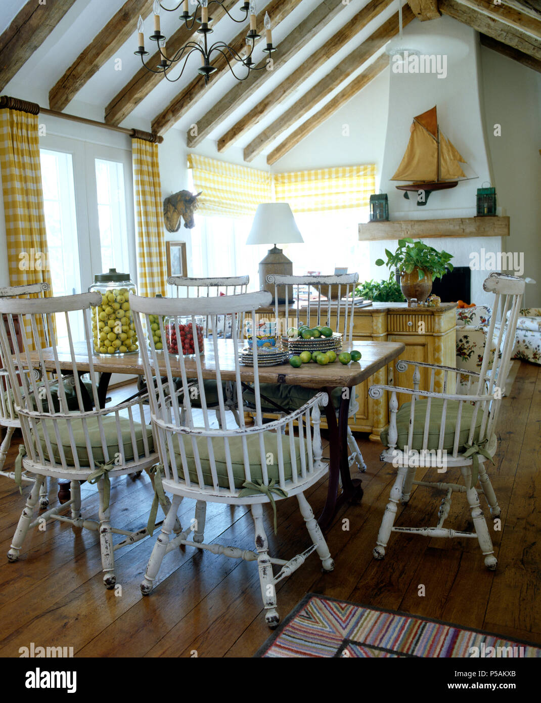 White stick back chairs at a simple wooden table in a country kitchen