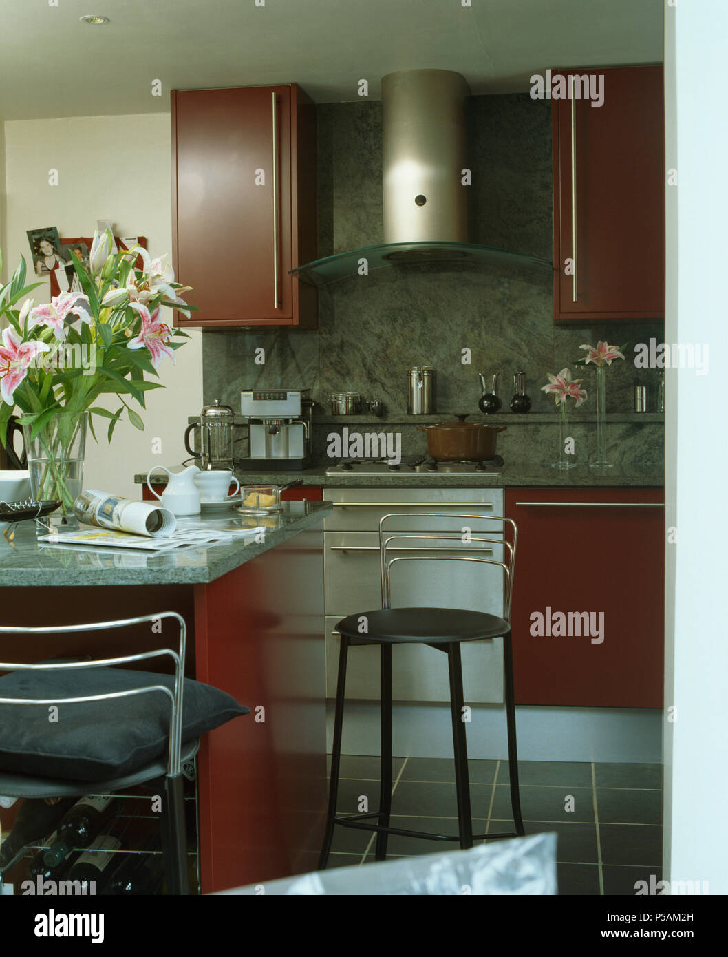 Chrome stools at breakfast bar in modern kitchen with stainlesssteel