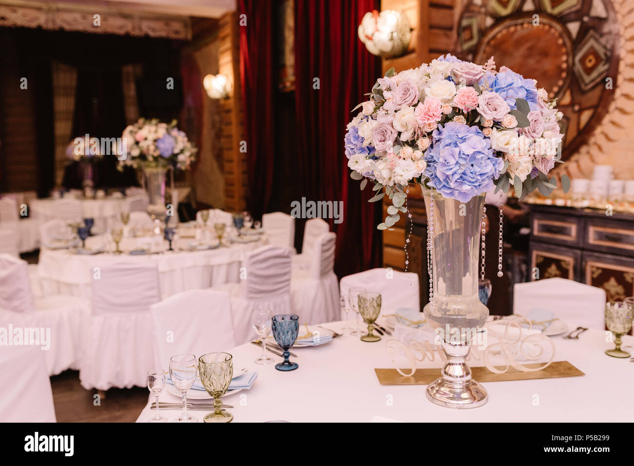 Magnificent, volume bouquets of flowers in high glass vases. Wedding