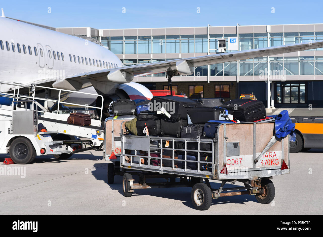 ground staff handling an aircraft before departure at the airport - loading luggage Stock Photo
