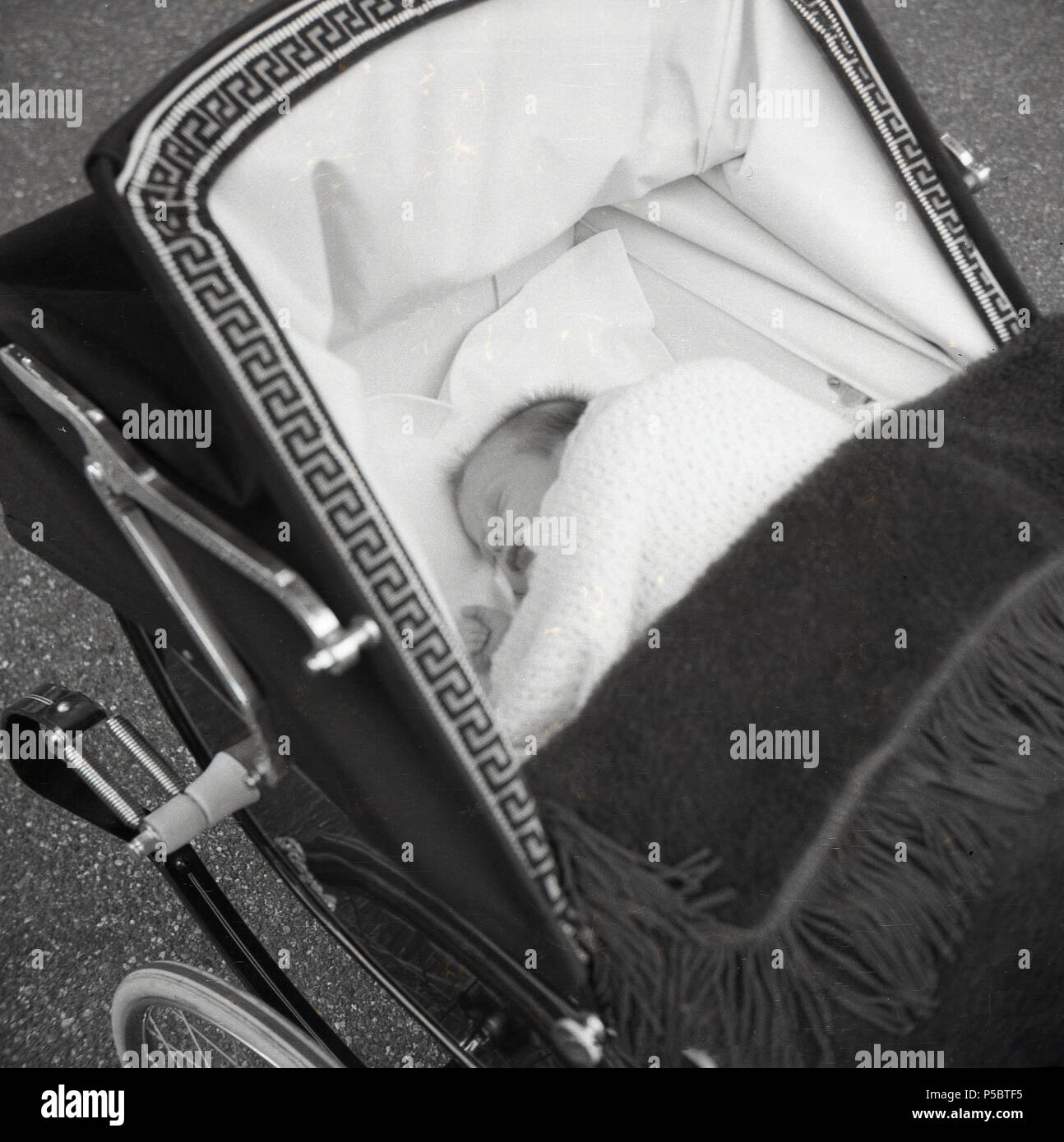 1950s, baby asleep in a coach built Royale baby carriage or pram, England, UK. A Royale was an elegant hand-made pram, the company having been founded by the Saward Brothers in Nuneaton Grove, London, in 1930 as the Royale Baby Carriage Co. Stock Photo