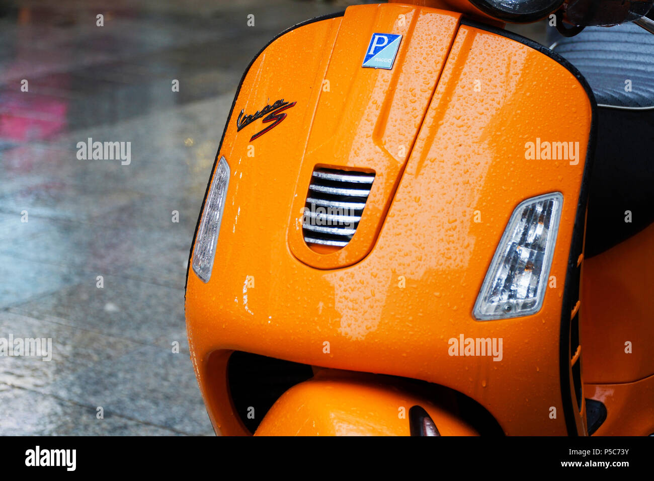 Istanbul, Turkey - December 31, 2016: Details of a wet orange Piaggio Vespa S in a rainy day at Istanbul Kadikoy. Stock Photo