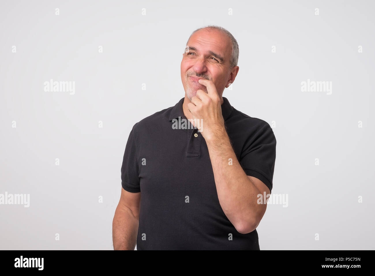 Middle aged man with hand looking up thinking Stock Photo