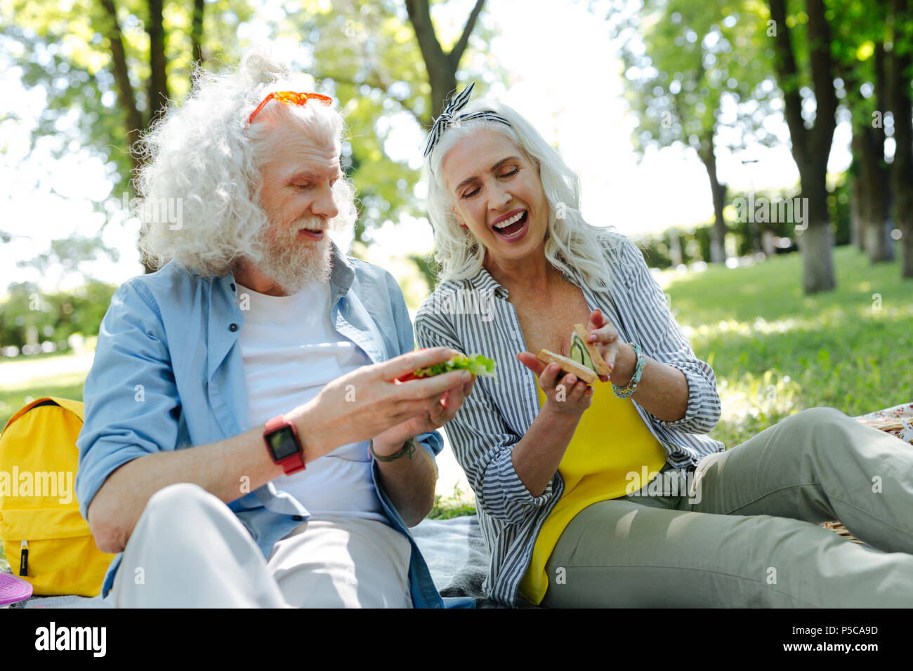 Delighted nice couple having sandwiches Stock Photo