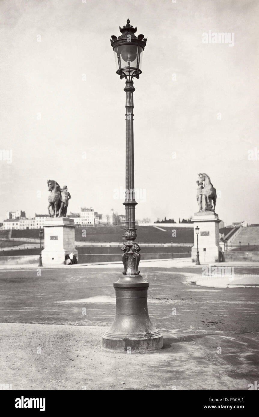 Champ de Mars. no. 18. English: Lamp post framed by two classical style  statues of man and horse of the pont d'Iéna and wide open lawn space in  background. Français : Lampadaire