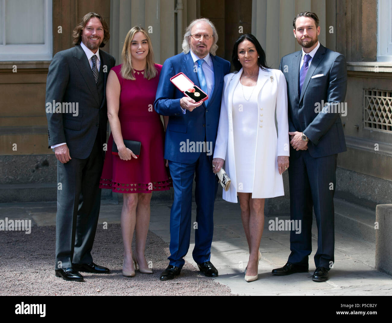 Singer and songwriter Barry Gibb, with his wife, Linda and children, Michael (right), Alexandra and Ashley (left) at Buckingham Palace, London, after he was knighted by the Prince of Wales during an investiture ceremony. Stock Photo