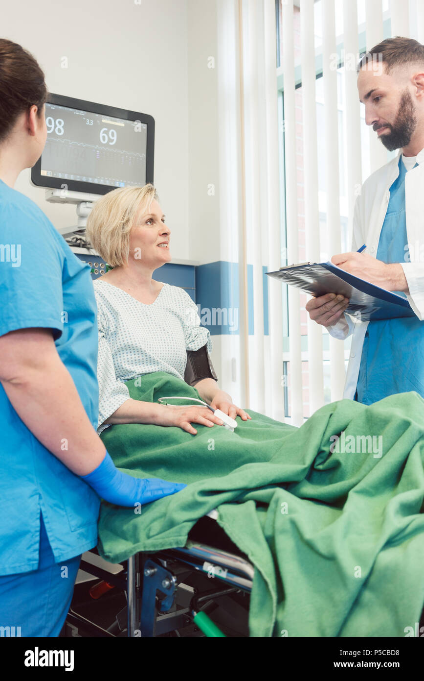 Doctor And Nurse Talking To Patient In Recovery Room Of