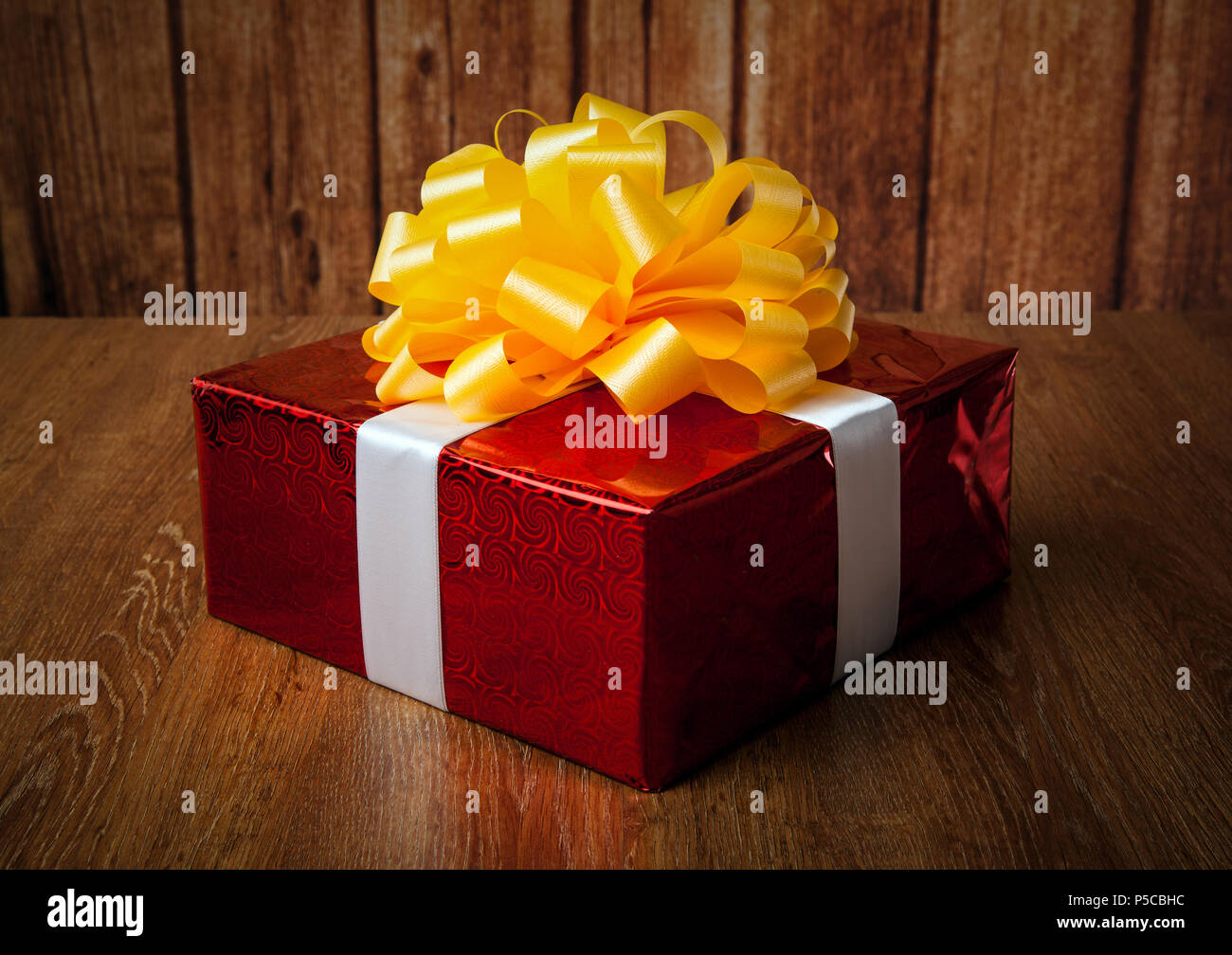 one large red gift box on a wood background Stock Photo - Alamy