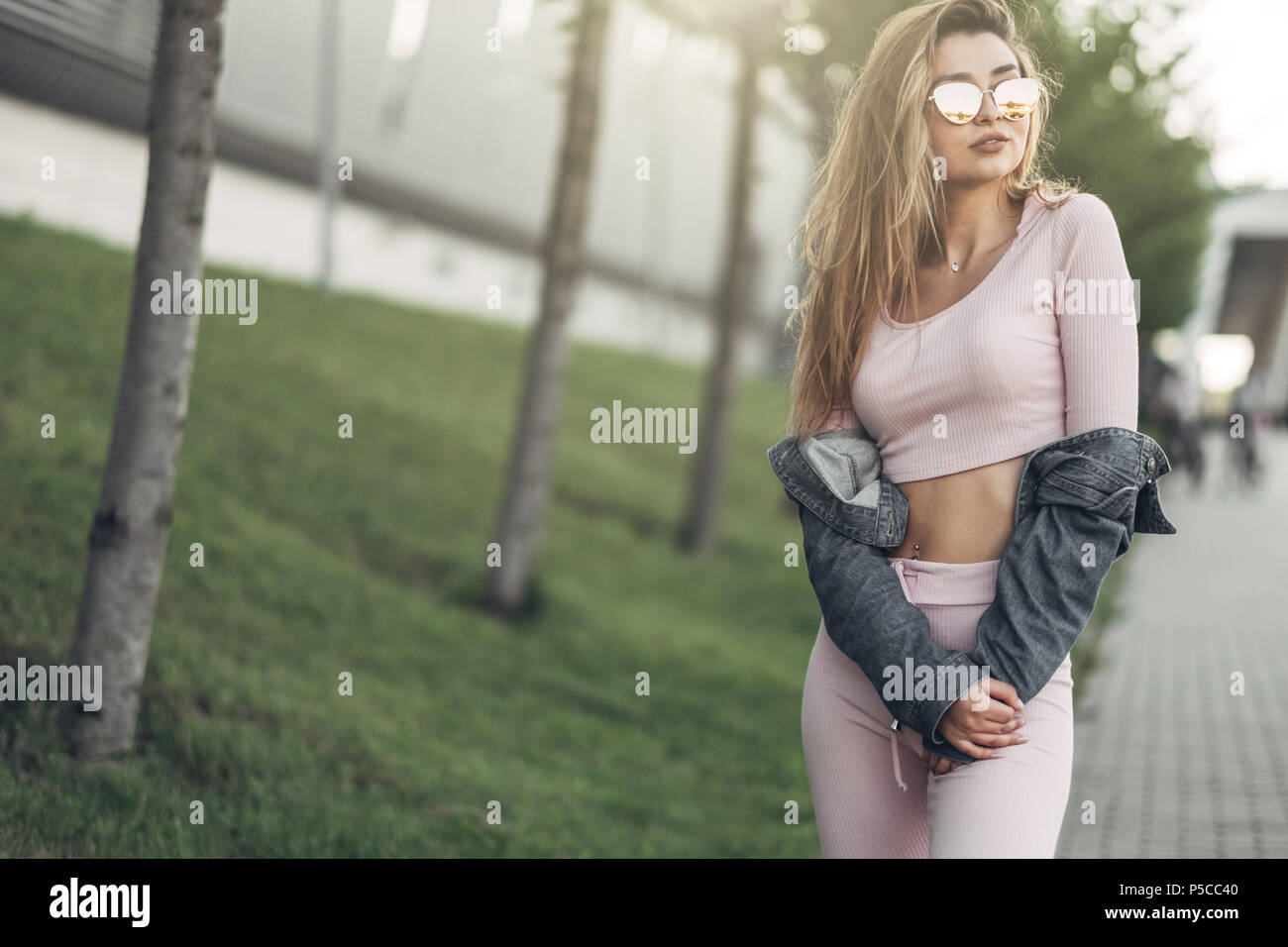 Portrait of Young and Beautiful Woman in Casual Clothes in the Street.  Dressed in Pink Shirt and Pants. Spring, Summer Concept. Relax Time. Girl  with Stock Photo - Alamy