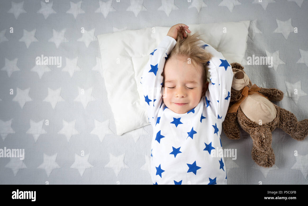 six years old child sleeping in bed with alarm clock Stock Photo Alamy