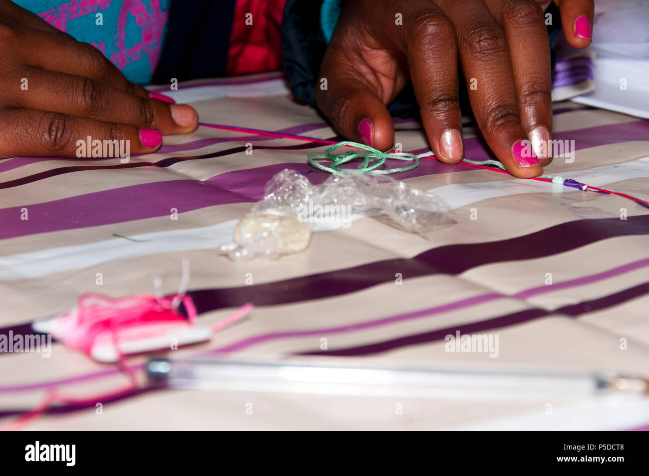 Childs hands sewing with a needle and thread Stock Photo - Alamy