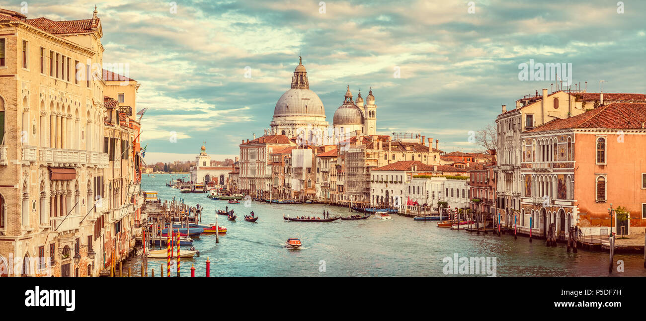 Classic panoramic view of famous Canal Grande with scenic Basilica di Santa Maria della Salute in beautiful golden evening light at sunset with retro  Stock Photo