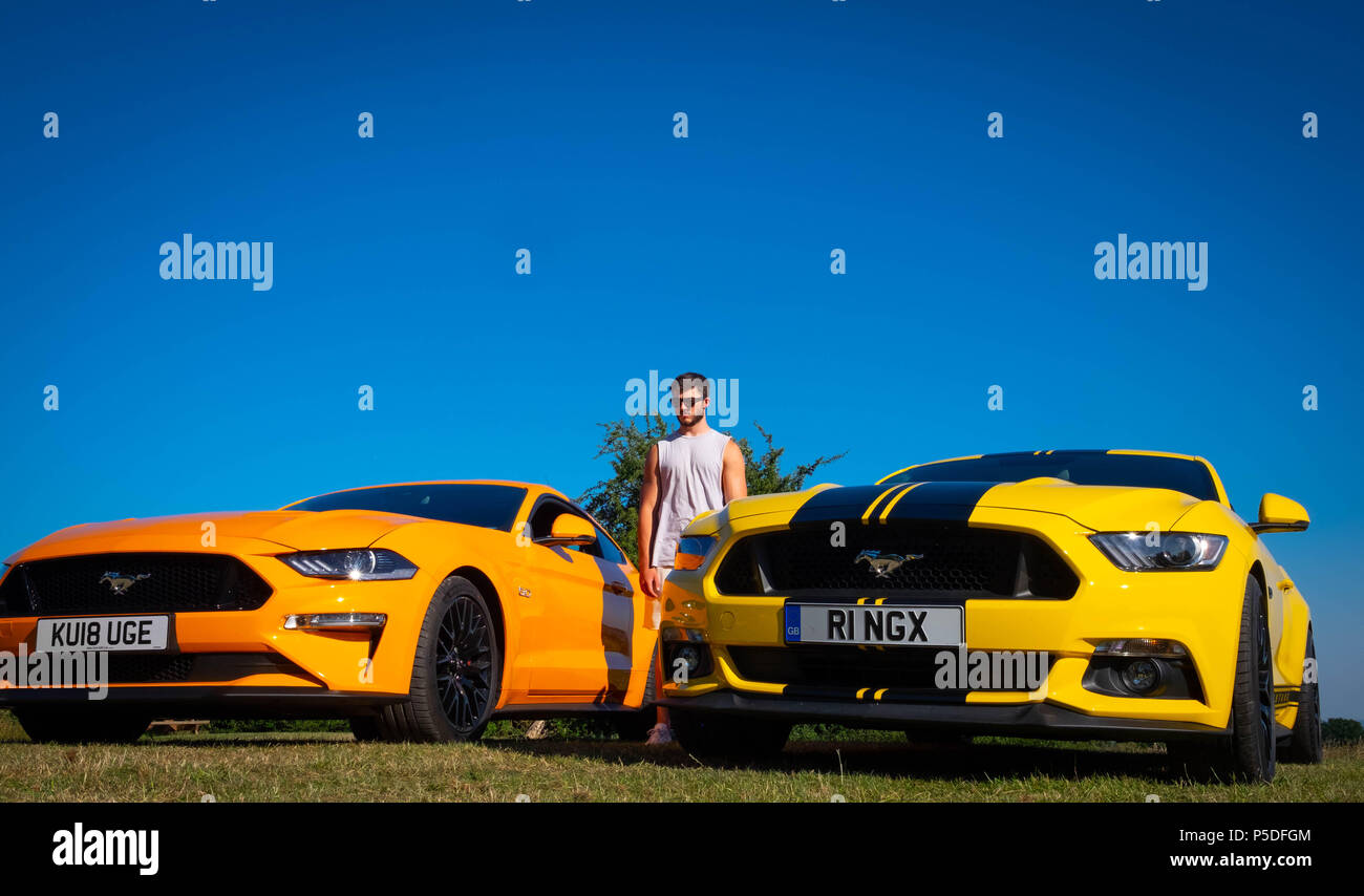 2 Ford Mustang 5 litre V8 GT Fastback Auto European cars with muscular man in the UK Stock Photo