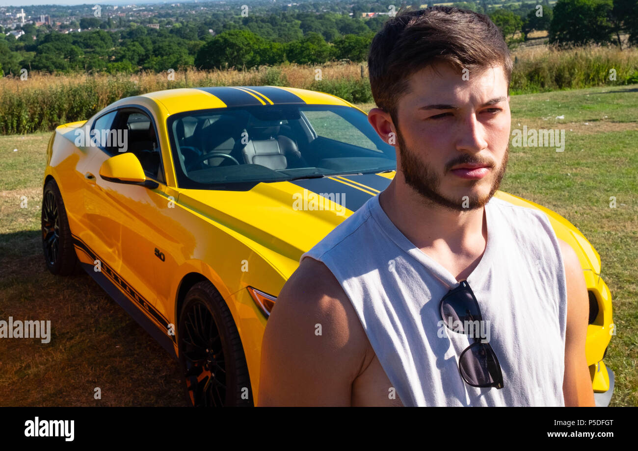 Muscular young man poses with a European Ford Mustang 5 litre V8 GT  Fastback Auto sports car in the UK Stock Photo - Alamy