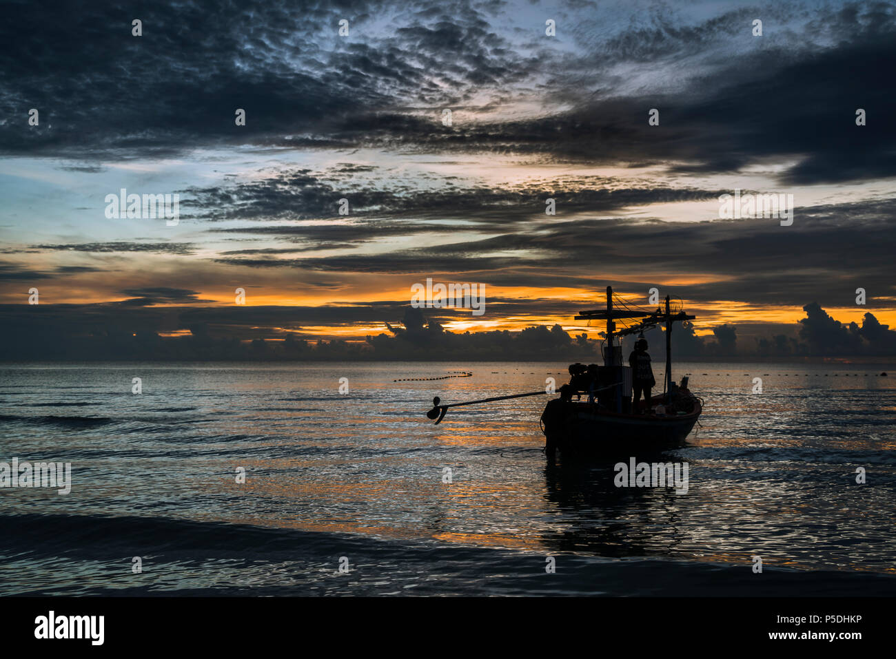 A beautiful tropical dawn with a fishing boat. Stock Photo