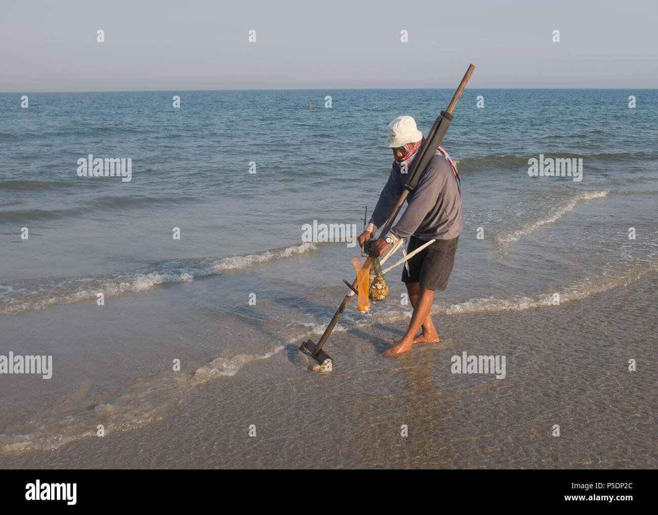 Man raking for clam shells on the beach, Prachuap Khiri Khan Province, Hua Hin, Thailand, Asia. Stock Photo