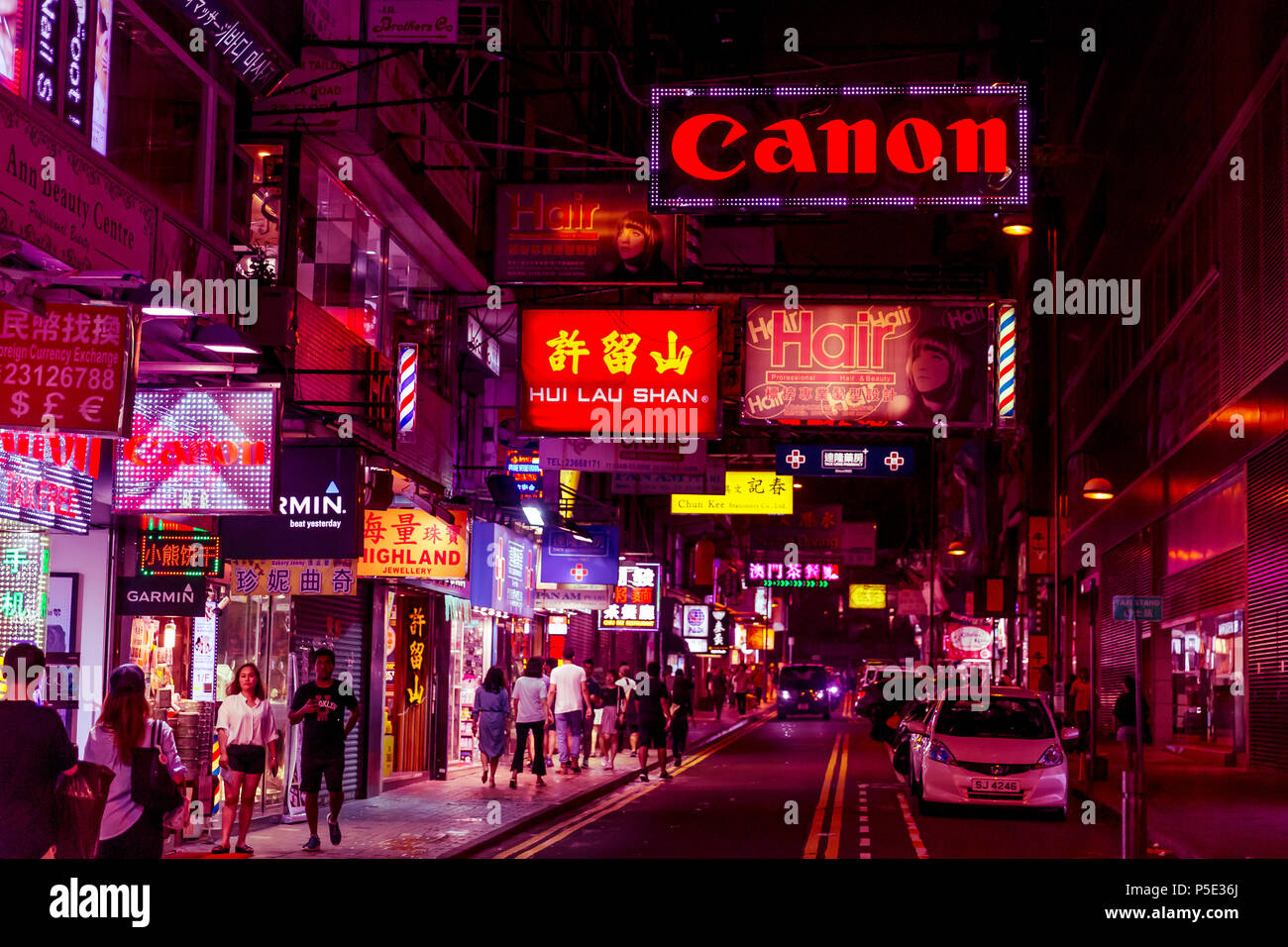HONG KONG - JUNE 01, 2018: People shopping at night on pink neon streets in Hong Kong Stock Photo