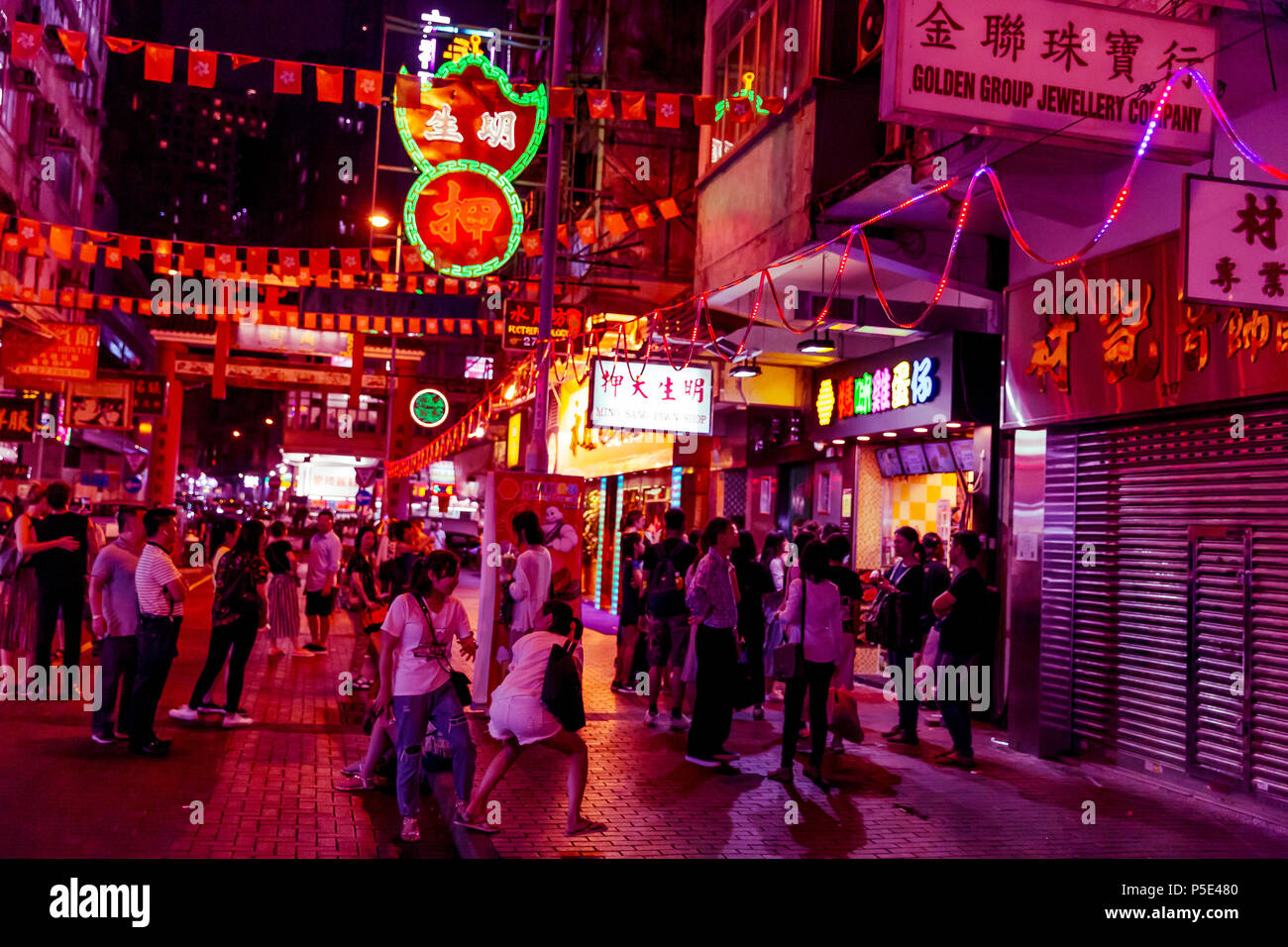 HONG KONG - JUNE 01, 2018: People shopping at night on pink neon streets in Hong Kong Stock Photo
