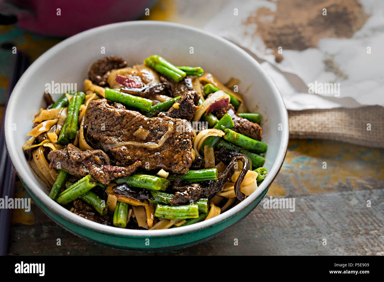 Wok fried beef, green beans, mushroom with rice noodles Stock Photo