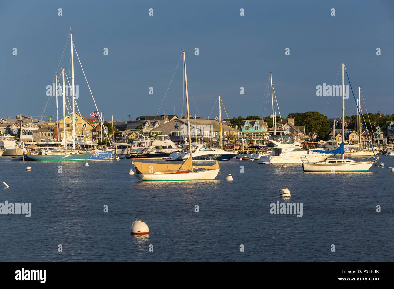 Sailboats and other pleasure craft moored in the harbor shortly before sunset in Oak Bluffs, Massachusetts on Martha's Vineyard. Stock Photo