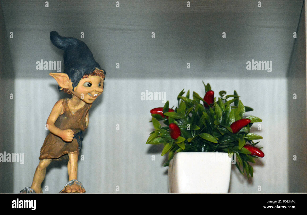 Un Elfo accanto ad una pianta con bacche rosse Stock Photo