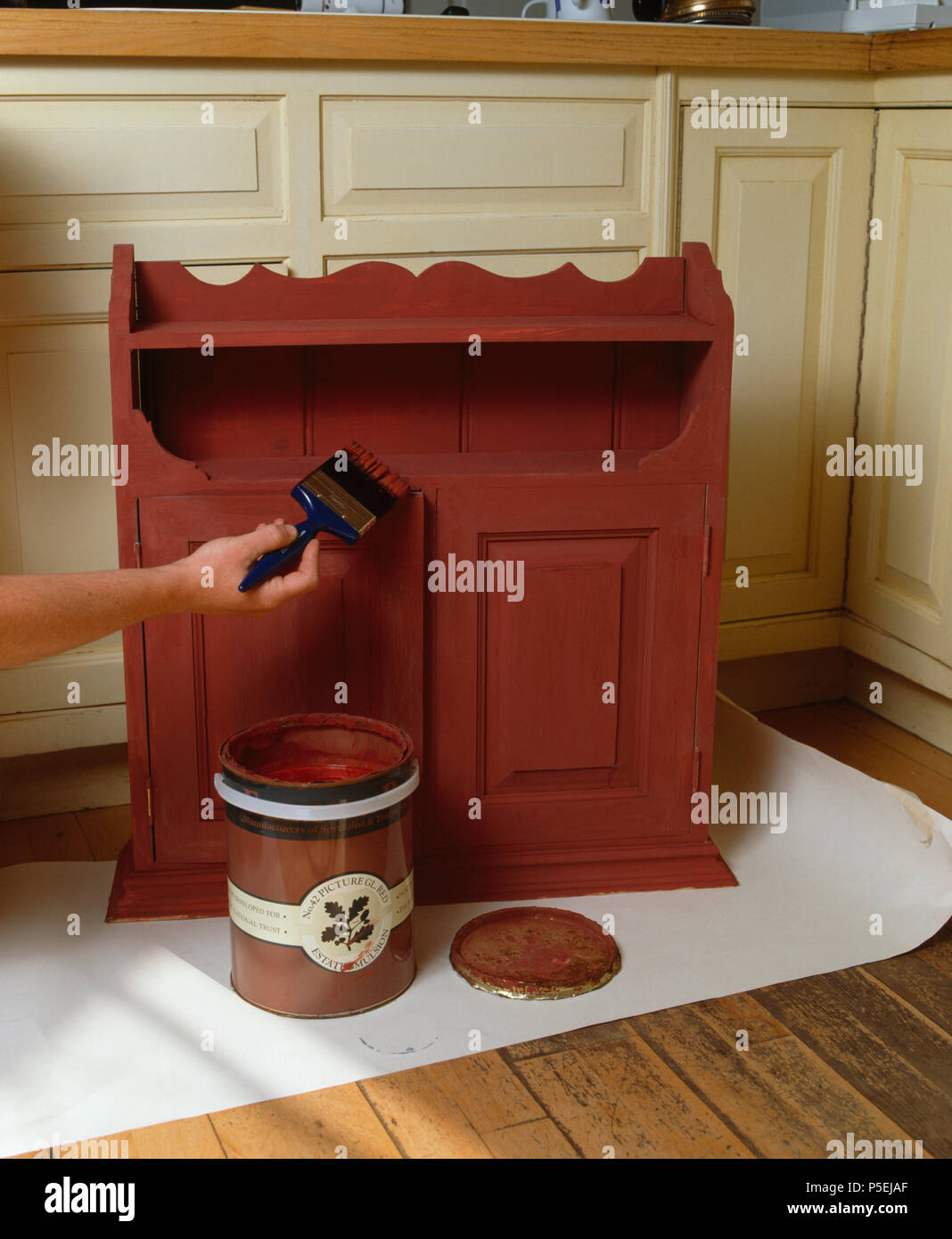 A hand renovating a small pine cupboard Stock Photo Alamy
