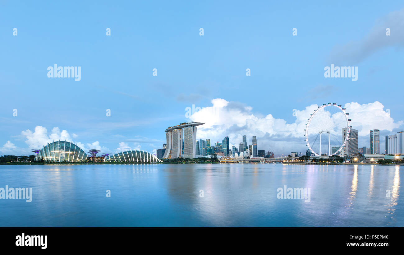 Sun rising over the downtown skyline of Singapore as viewed from across the water from The Garden East. Singapore. Stock Photo