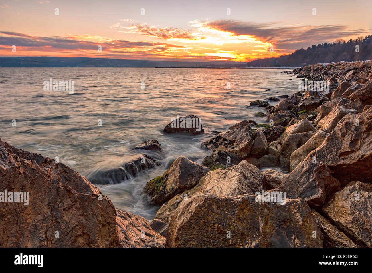 Exciting sunset. Beauty sea rocky coast with waves motion blur. Varna, Bulgaria Stock Photo