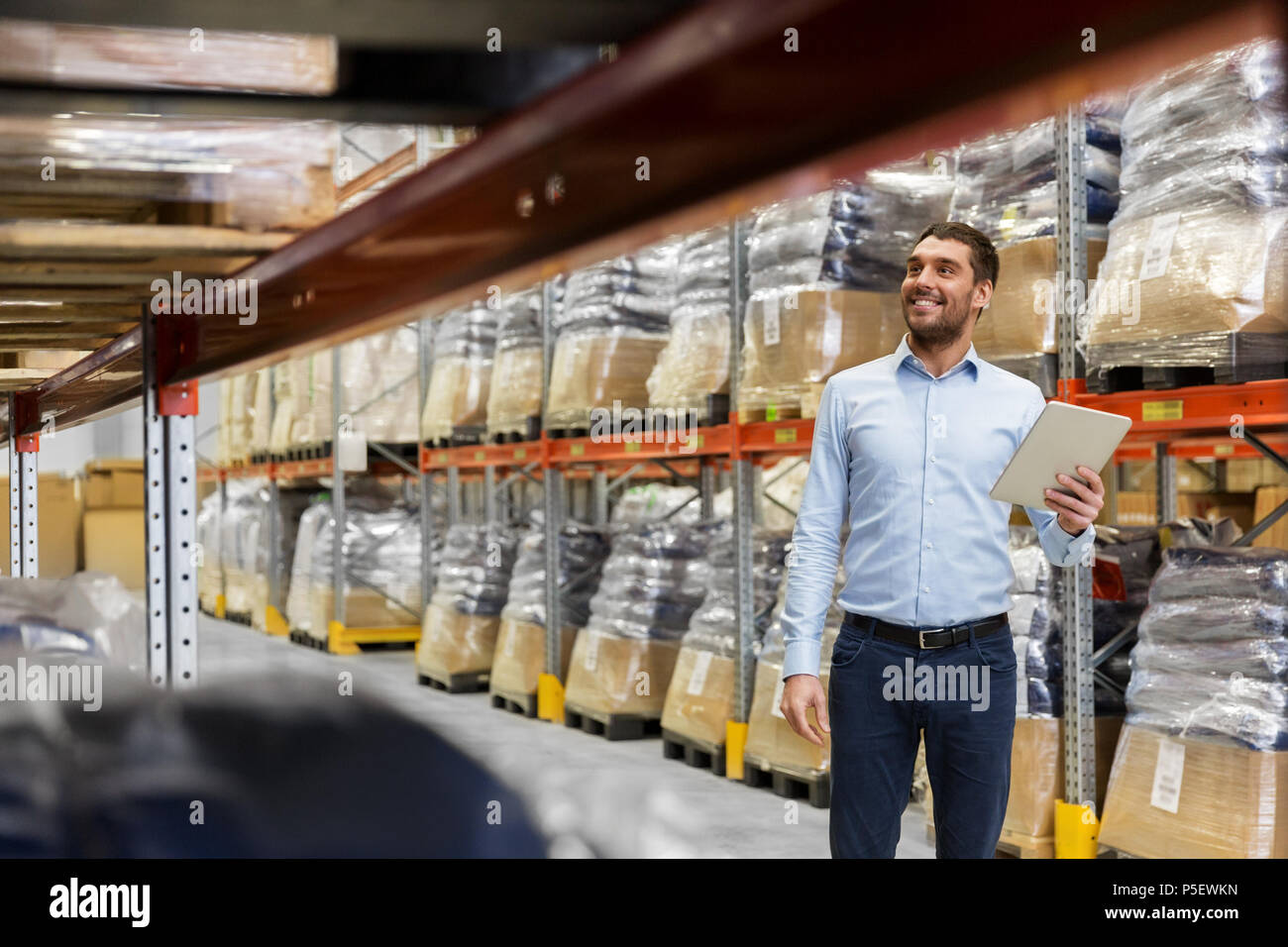 happy businessman with tablet pc at warehouse Stock Photo