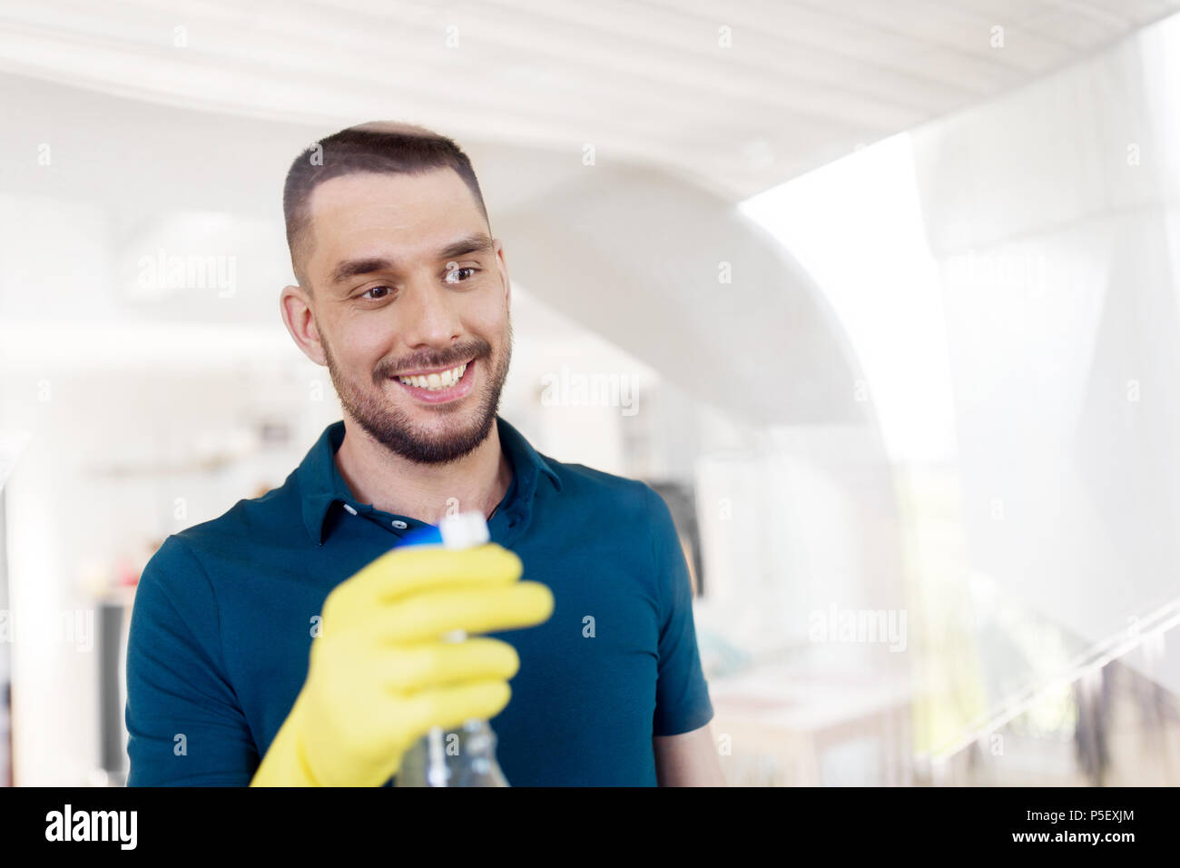 man in rubber gloves cleaning window with spray Stock Photo