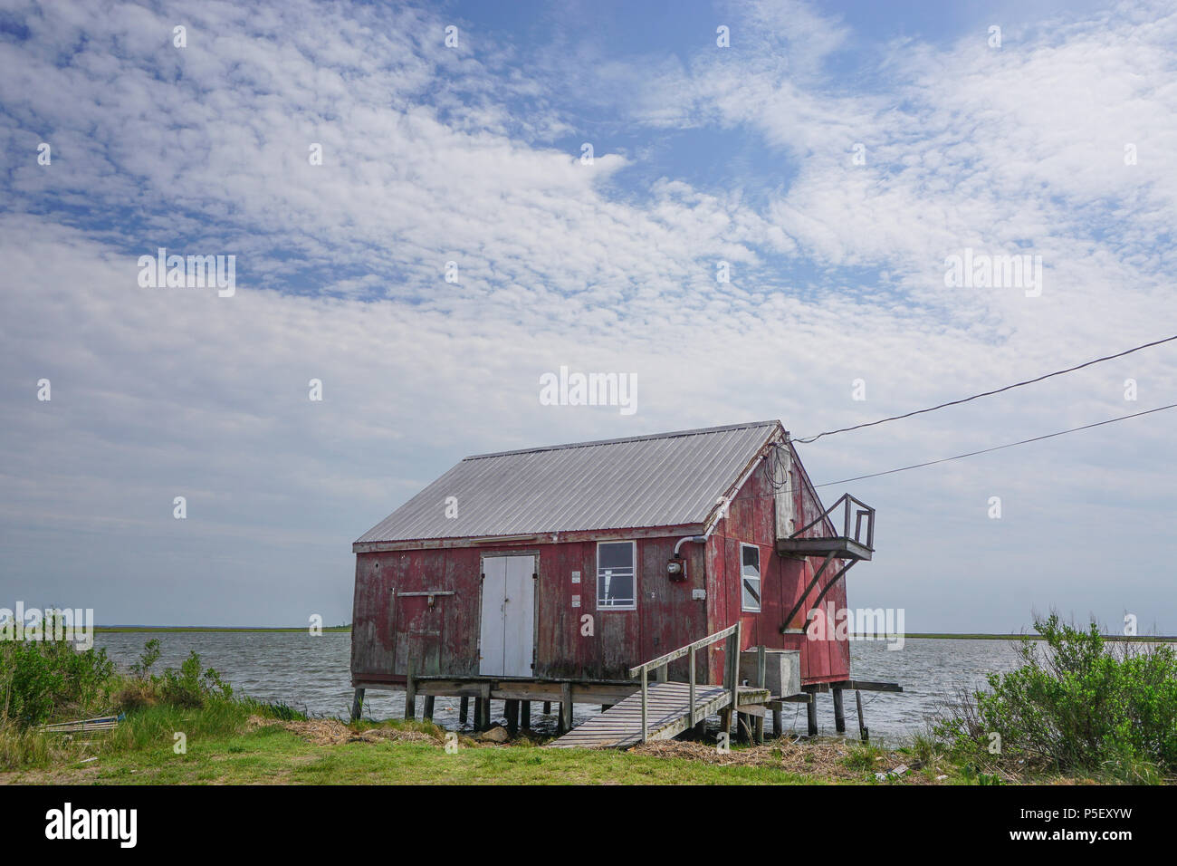 Saxis, Virginia / USA - May 15, 2018: An old red crab house on the edge of the Pokomoke Sound in the fishing town of Saxis, Virginia. Stock Photo