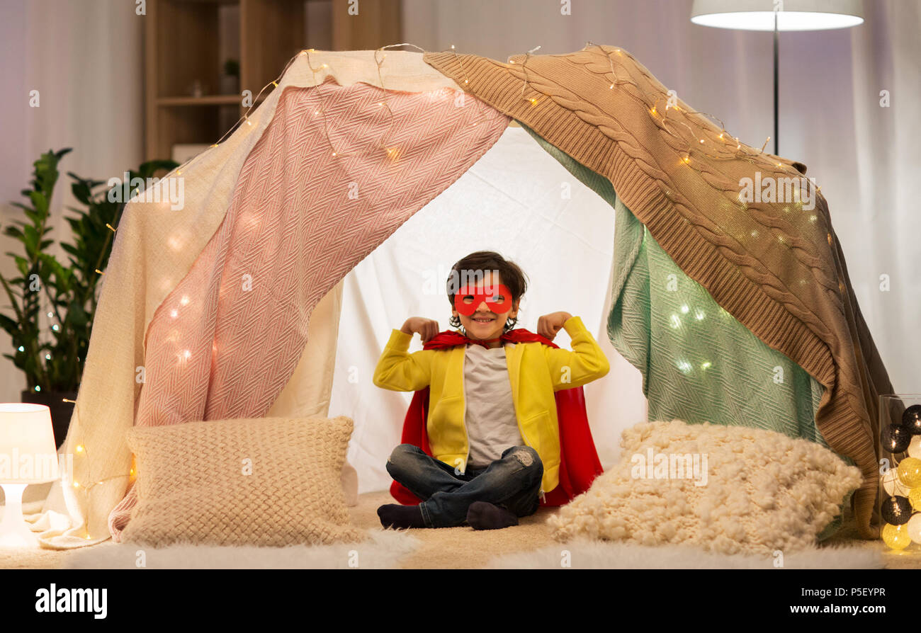 happy boy in super hero stuff in kids tent at home Stock Photo
