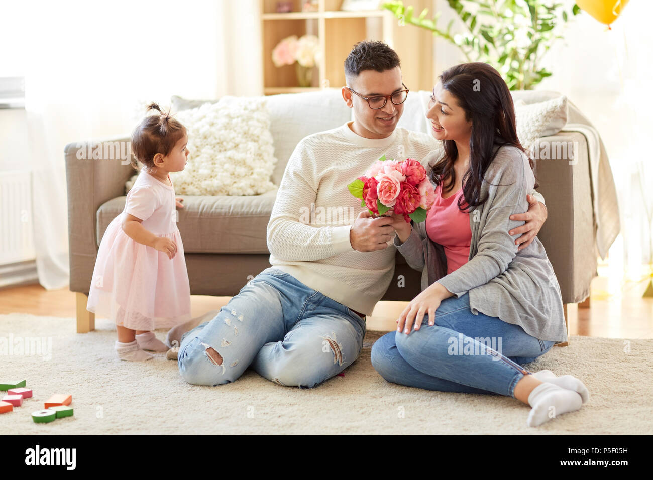 happy husband giving flowers to his wife at home Stock Photo Alamy
