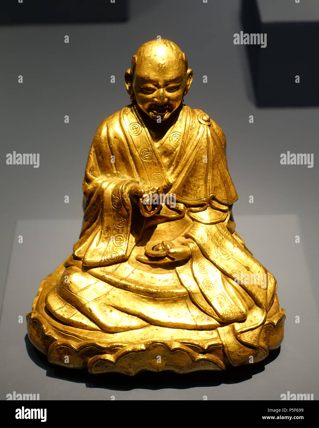 N/A. English: Exhibit in the Linden-Museum - Stuttgart, Germany. 6 December 2015, 12:05:43. Daderot 122 Arhat Kalika, Tibet in a Chinese style, c. 16th-17th century AD, firegilt bronze - Linden-Museum - Stuttgart, Germany - DSC03698 Stock Photo